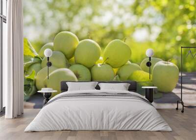 green apples on wooden table in sunlight outdoor Wall mural