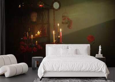 magic potion with red roses and burning candles in dark room Wall mural