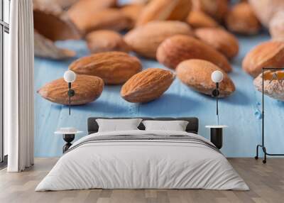 salted almonds in shell on wooden background Wall mural