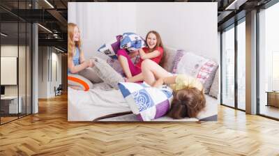 teenage girls  having fun and fighting with pillows Wall mural