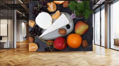 Still life with Dutch cheese and seasonal fruit on dark grey textured background with space for text.  Wall mural