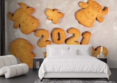 Woman hand cutting cookies, year 2021 on dark board with baking flour. rolling pin, flour and shape of new year figures. Wall mural