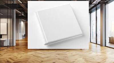 Mockup of closed blank square book at white textured paper background. Angle view Wall mural