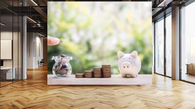 Close up hand putting coin into glass bottle, Piggy bank and stack of coins. The concept of saving money, Financial, Investment and Business growing up. Wall mural