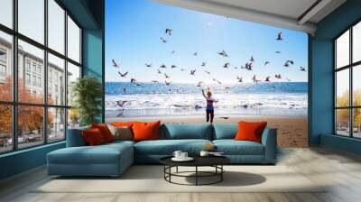 Happy and free boy on the beach with seagulls Wall mural