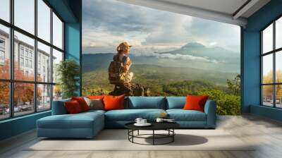 Woman enjoying sunrise from a top of mountain Batur, Bali, Indonesia. Wall mural