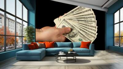 Fan of dollars in a male hand on a black background Wall mural