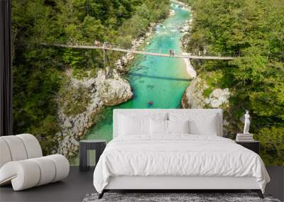 A suspension bridge spans the emerald waters of the Soca River in Slovenia Wall mural