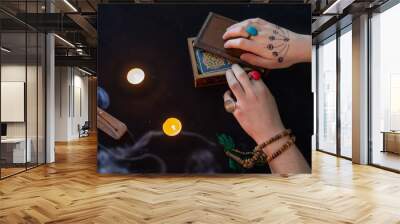 Fortune teller using tarot cards on black background Wall mural