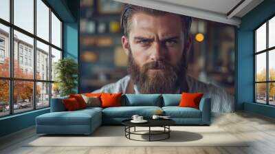 Close-up portrait of a man with a beard, looking intensely at the camera. Wall mural