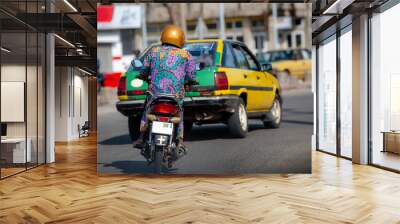 Motorbike in traffic of Cotonou, Benin. The people of Benin in daily life, lifestyle of West Africa. Fashion of Benin, West-Africa. Wall mural