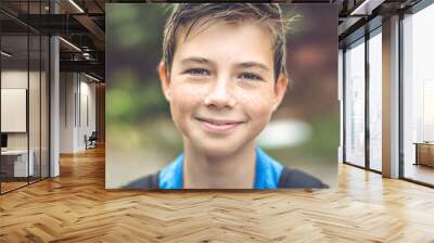 Close-up of wet child with freckles. Baby laughs looking at the camera. He is happy and cheerful. Wall mural