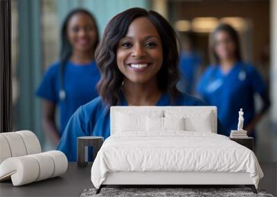 Female student medical staff in blue scrubs smiling at the camera, standing side by side with one looking directly into frame and two behind. Wall mural