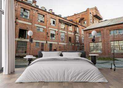 Abandoned multi-story brick factory building with broken glass windows. Wall mural