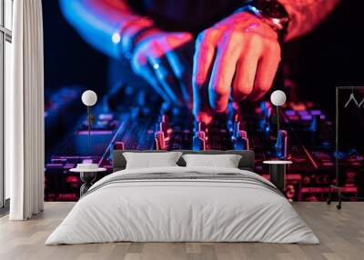 Close up of DJ hands controlling a music table in a night club. Wall mural