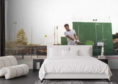 Young Man Playing Tennis Outdoors. Wall mural