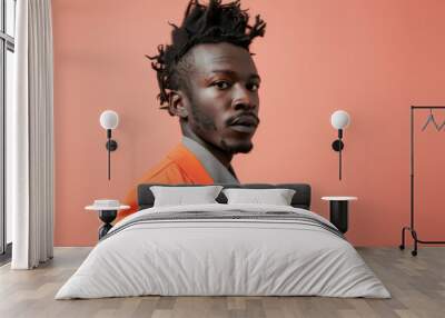 A handsome Black man Confident smile portrait of a young Black man in a vibrant orange suit against a bold orange backdrop Wall mural