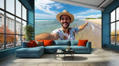 A happy man taking a selfie at the beach, wearing summer attire and a hat Happy tourist take selfie self-portrait with smartphone man on vacation looking at camera - Holidays and travel concept Wall mural