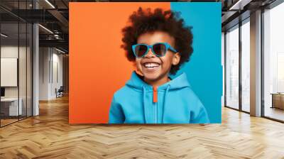 Boy wearing casual clothes with bright colored glasses standing over isolated plain background doing laughing and smiling. Wall mural