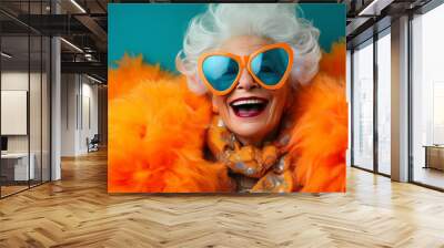 Happy smiling mature woman on colorful background. senior woman, dressed in a colorful neon outfit, dons quirky sunglasses and showcases her extravagant style Wall mural