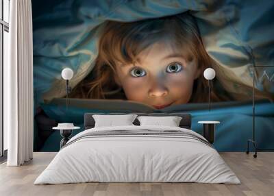 Young girl reading under the covers with her eyes wide open, illuminated by a torch flashlight of an old frightening scary children s book's. Dark, moody lighting Wall mural