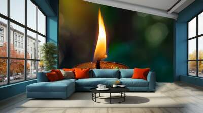 Close up of a burning candle on a green background Wall mural