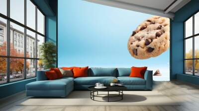 Photo of a chocolate chip cookie flying, on a blue background. Web banner with copy space on the right. Wall mural