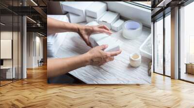 Woman hands working with carton box and paper post envelope Wall mural