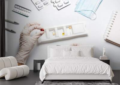 Woman nurse fills the medication organizer in hospital Wall mural