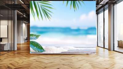 wooden table top with white sand and palm tree leaves on the beach background with blur blue sea Wall mural