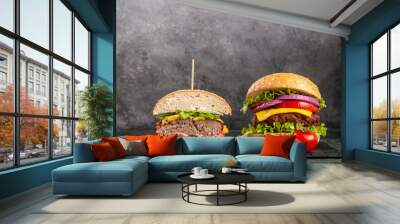 Two delicious homemade burgers of beef, cheese and vegetables on an table. Fat unhealthy food close-up, Two hamburgers with beef burger cutlet, fried onion, spinach, ketchup sauce and blue cheese. Wall mural