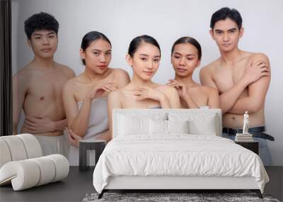 Group of sexy young adults, 3 women wrapped in towels and 2 half naked men with neutral expressions, pyramid formation, representing skincare or spa concepts. Wall mural