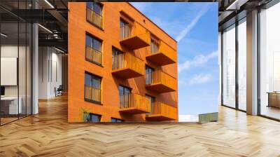 Modern apartment buildings on a sunny day with a blue sky. Orange Facade of a modern apartment building. Wall mural