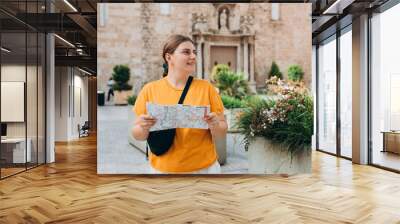 Young beautiful 30s woman looking city map at street, old town. Attractive young female tourist is exploring new city. Traveling Europe, High quality photo Wall mural