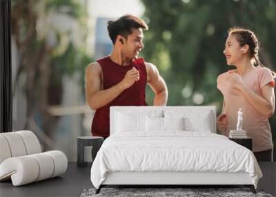 Active two Asian young man and woman in sportswear jogging exercise in park outdoor. Together young couple running outdoor in the morning. Healthy exercise concept. Wall mural