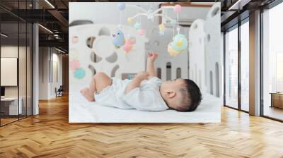 Adorable Asian Baby Boy, 5 Months Old, Smiling and Enjoy Playing with Crib Mobile in Home Playpen. Wall mural