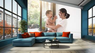 Asian mom smiling happy holding and playing clap hand with her son. Mom and baby in mother’s day concept. Wall mural