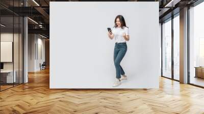 Full length of cheerful Asian woman smiling with using smartphone trading or promotion shopping online on isolated white background. Successful young female trading in smartphone. Creative collage. Wall mural