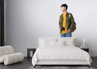 Full length of confident asian man backpacker in a casual outfit, standing and looking to copy space on isolated white background. Fashion Asian man traveller in studio shot. Wall mural