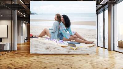 two girls sitting on a laptop and read books on vacation holiday concept travel lgbtq Wall mural