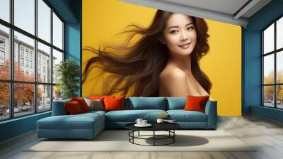 portrait studio shot of an asian female model with long black hair smiling for the camera with orange yellow theme Wall mural