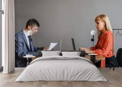 A business woman and man at the office desk, face to face Wall mural