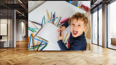 little boy paints greeting card with colour pencils and smile Wall mural