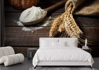 Bunch of wheat ears and wooden spoon with flour on wooden rustic table. Wall mural