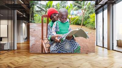 A brother helps his sister with homework in the village in Africa Wall mural