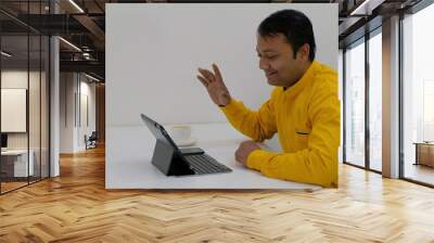 Happy Indian male having a video conversation on a tablet Wall mural