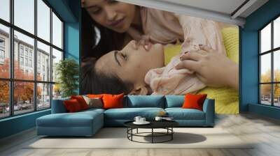 Two pretty girlfriends from India cuddling  at home Wall mural