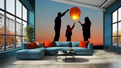 Parents, child and baby silhouette rising lightning sky lantern, conceptual release hope, free dreams of happy family Wall mural