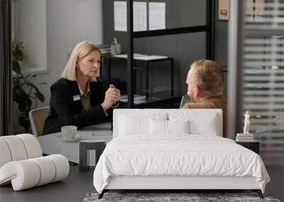 Portrait of caring social worker consulting man behind glass wall in office Wall mural