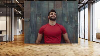 A man in a red shirt is smiling and looking up at the camera Wall mural